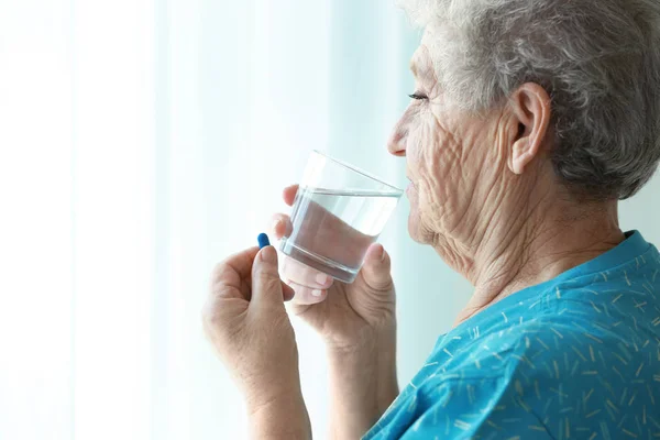 Mujer de edad avanzada tomando píldora —  Fotos de Stock