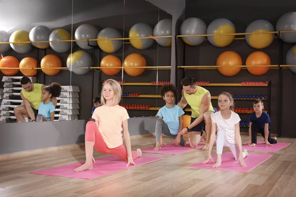 Los niños en la lección de educación física en el gimnasio escolar —  Fotos de Stock