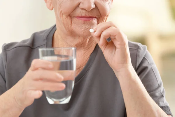 Mujer de edad avanzada tomando píldora —  Fotos de Stock