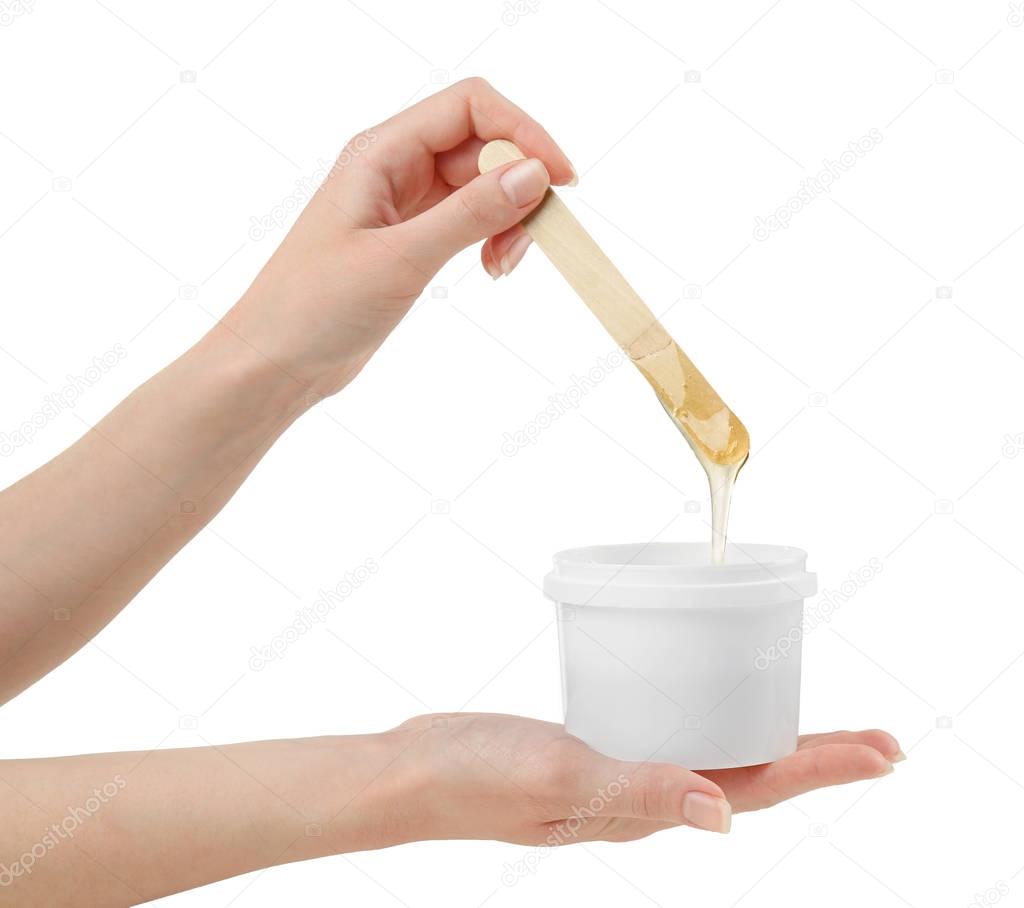 hands with wooden stick and sugaring paste