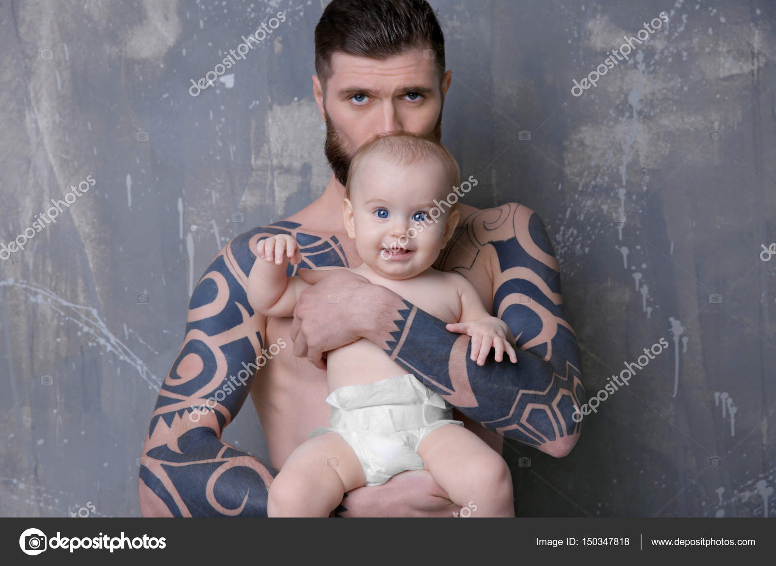 Beau Jeune Homme Tatoue Tenant Mignon Petit Bebe Sur Fond Gris Image Libre De Droit Par Belchonock C