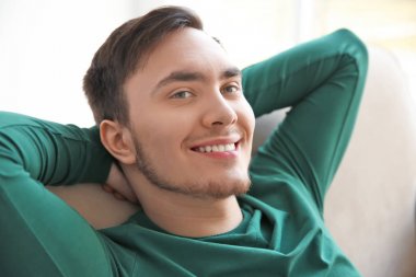 Mutlu genç adam kanepede oturan