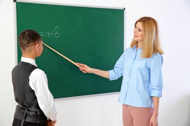 Kadın öğretmen ve öğrenci sınıfta blackboard