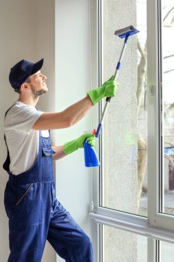 Genç adam yıkama pencere 