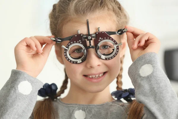 Carina bambina con cornice di prova nell'ufficio dell'oftalmologo — Foto Stock