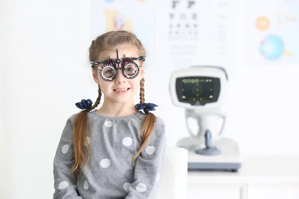 Linda niña con marco de ensayo en el consultorio del oftalmólogo —  Fotos de Stock