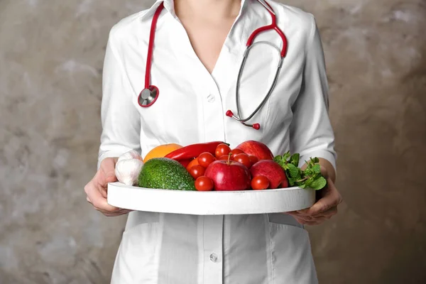 Arzt hält Tafel mit gesundem Essen — Stockfoto
