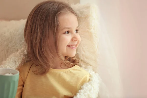 Schattig klein meisje in de buurt van venster thuis — Stockfoto