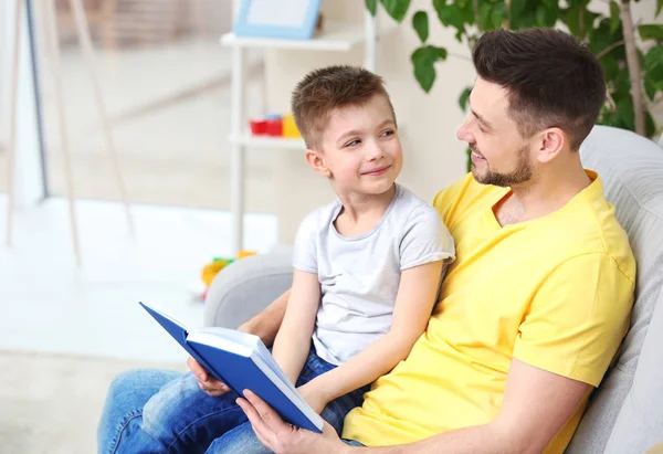 Papá e hijo leyendo interesante libro — Foto de Stock