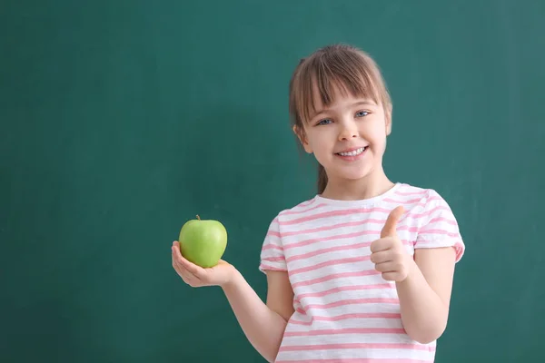 Happy schoolgirl sitting with apple — Stock Photo, Image