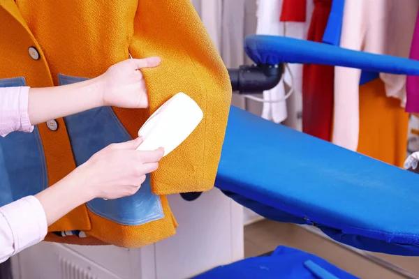 Female laundry worker cleaning coat with brush for clothes, closeup — Stock Photo, Image