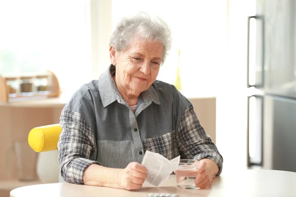 Elderly woman with pills — Stock Photo, Image