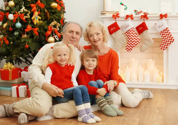 暖炉のそばに座って自分の孫娘と老夫婦がクリスマスの装飾 — ストック写真