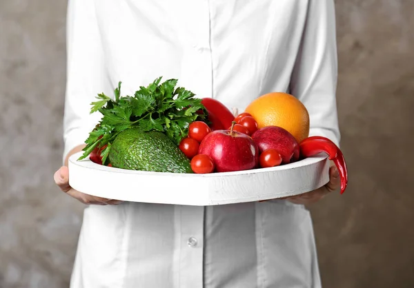 Doctor holding board with healthy food — Stock Photo, Image