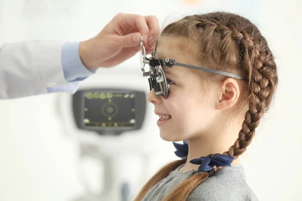 Офтальмолог осматривает глаза маленькой девочки в клинике — стоковое фото