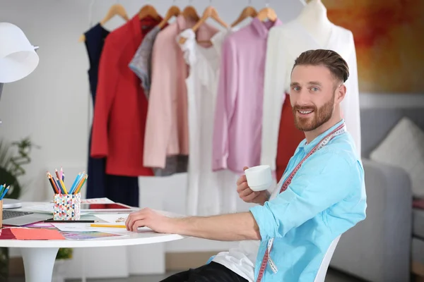 Young designer with cup of coffee — Stock Photo, Image