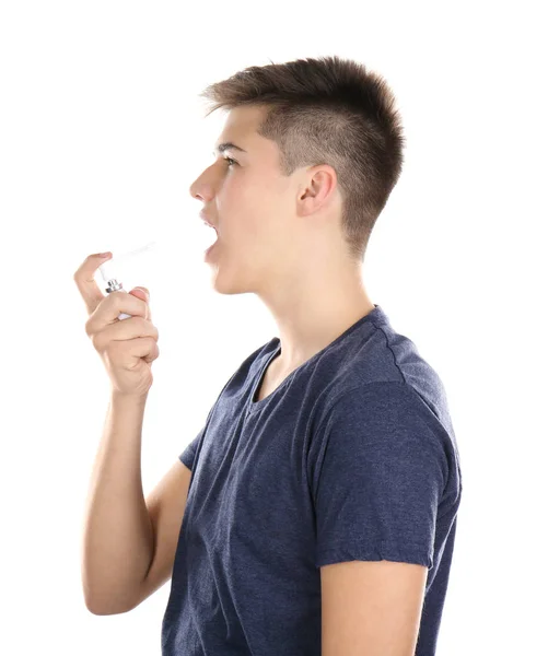 Sick young man using throat spray on white background — Stock Photo, Image