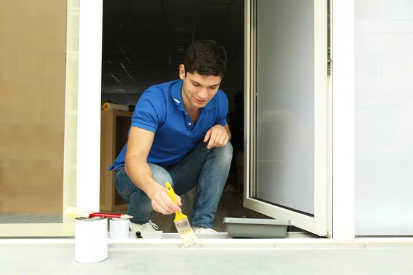 Hombre joven pintando ventana — Foto de Stock