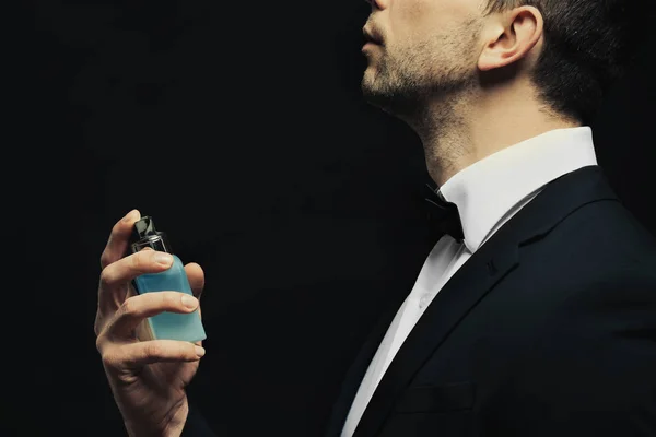 Handsome young man using perfume — Stock Photo, Image