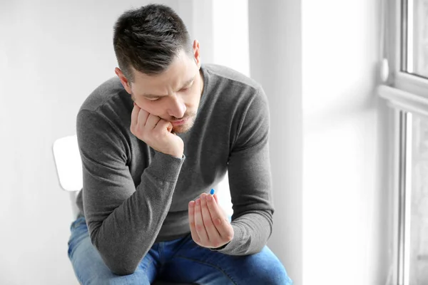 Schöner junger Mann mit Pillen — Stockfoto