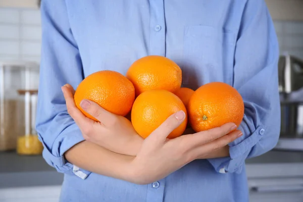 Woman holding oranges — Stock Photo, Image