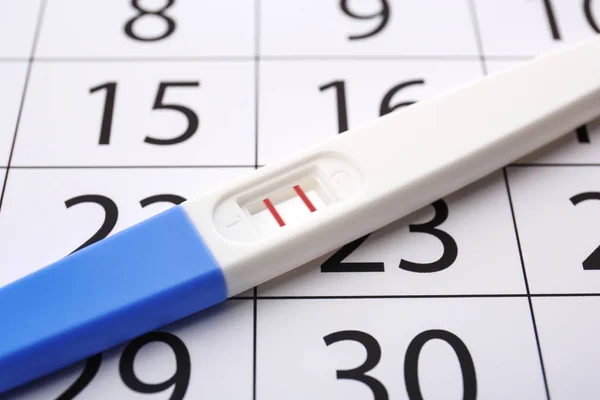 Pregnancy test on calendar — Stock Photo, Image
