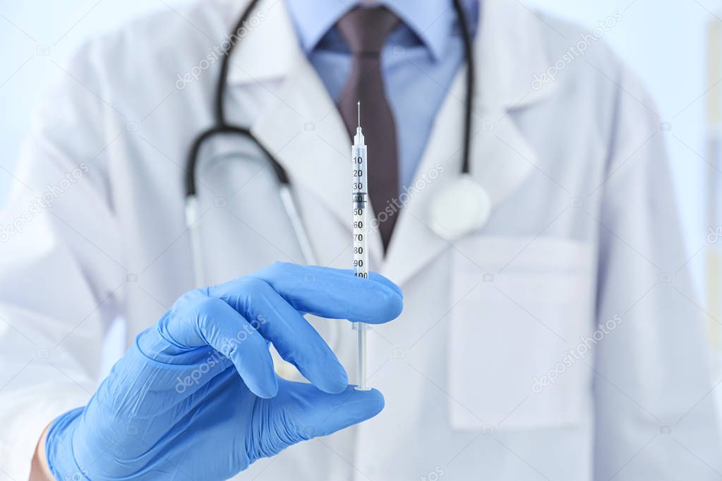 Doctor in gloves with syringe 