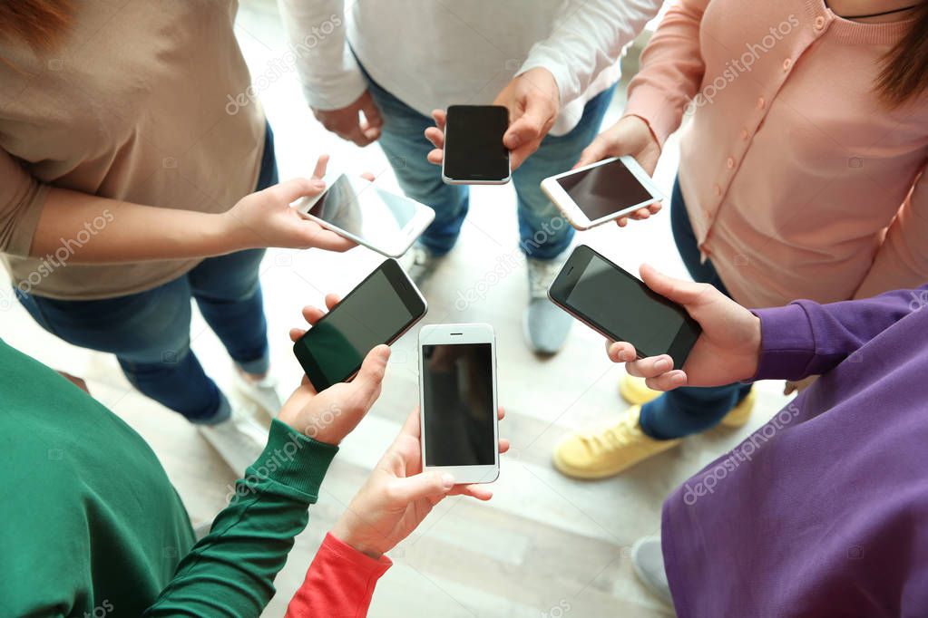 people standing in circle and using smartphones