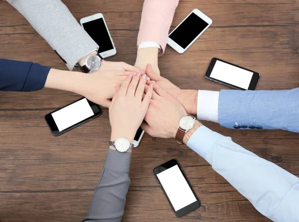 Team arbete koncept. Personer sittande vid bord och håller händerna ihop — Stockfoto