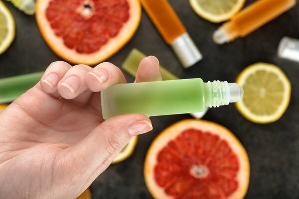 Женщина держит бутылку с духами.
 