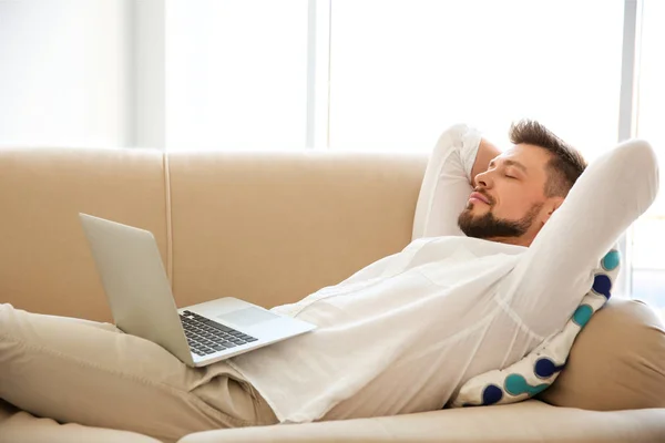 Ung man som ligger med laptop — Stockfoto