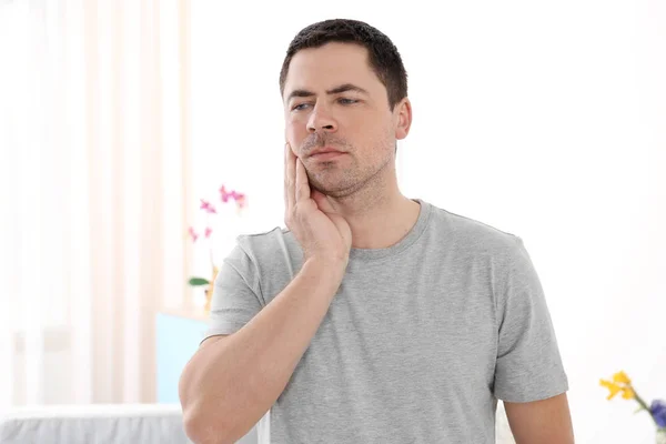 Мужчина, страдающий от зубной боли дома — стоковое фото