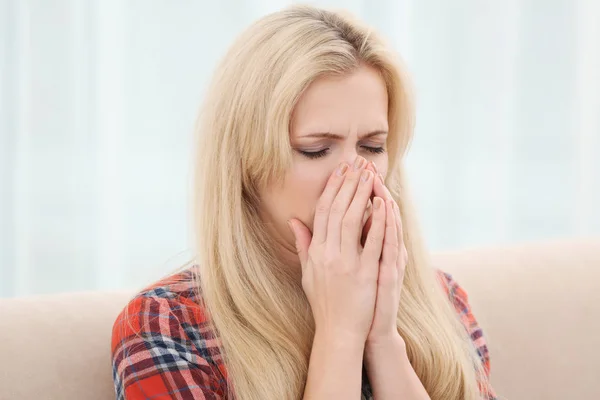 Junge Frau mit Allergie sitzt zu Hause auf Sofa — Stockfoto