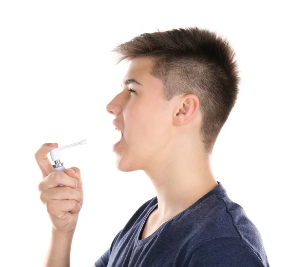 Sick young man using throat spray on white background — Stock Photo, Image