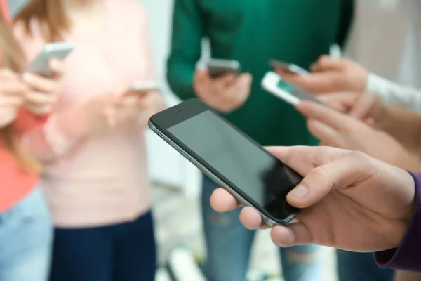 Menschen, die zusammenstehen und Smartphones nutzen — Stockfoto