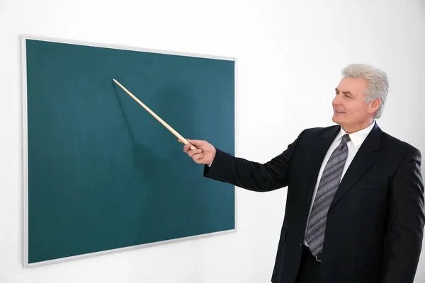 Ledande lärare med pekaren står nära blackboard — Stockfoto