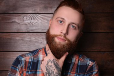 Sakallı adam ahşap arka plan üzerinde poz