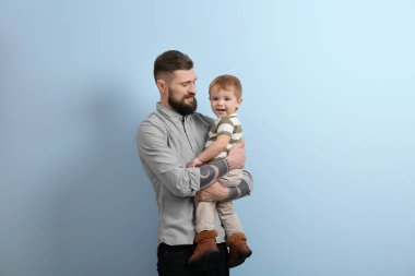 küçük çocuk tutan genç adam