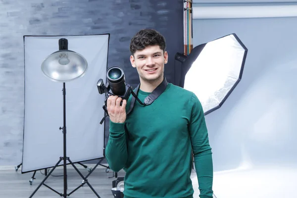 Junger professioneller Fotograf mit Kamera im Studio — Stockfoto