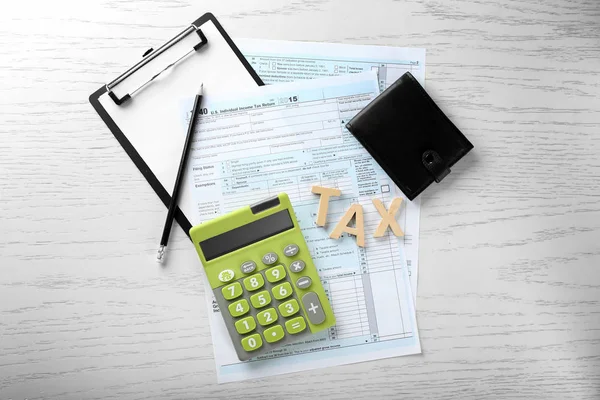 Groene calculator met documenten op tafel — Stockfoto