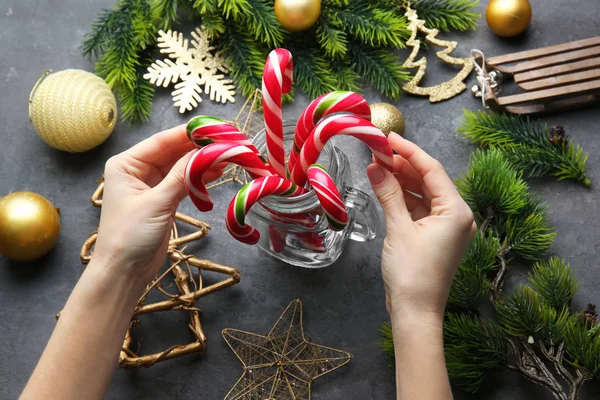 Manos sosteniendo bastones de caramelo de Navidad — Foto de Stock