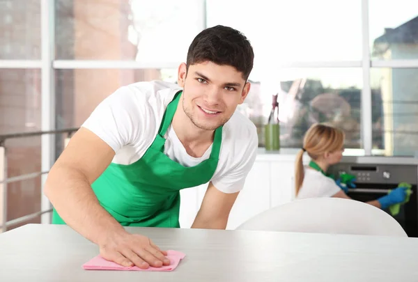 Młody człowiek czyszczenia kuchennym stole — Zdjęcie stockowe