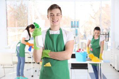 Ofiste iş yerinde genç erkek süpürge