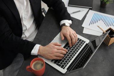 Genç iş adamı dizüstü bilgisayarla çalışıyor