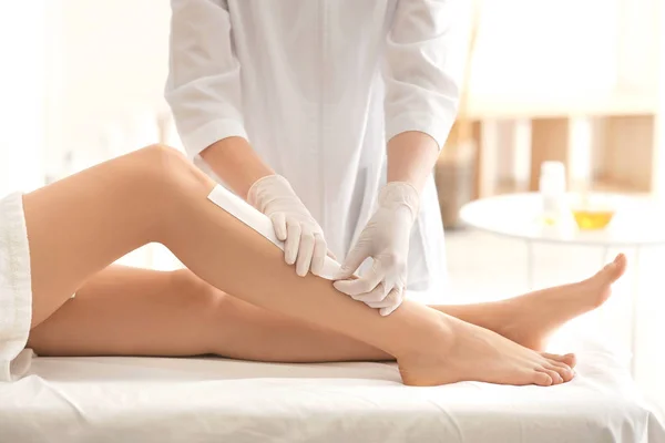 Kosmetyczka woskowanie kobiece nogi — Zdjęcie stockowe