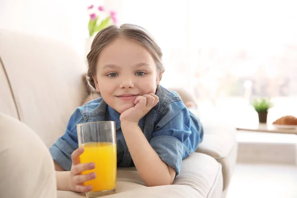 Gadis kecil yang lucu dengan segelas jus di rumah — Stok Foto