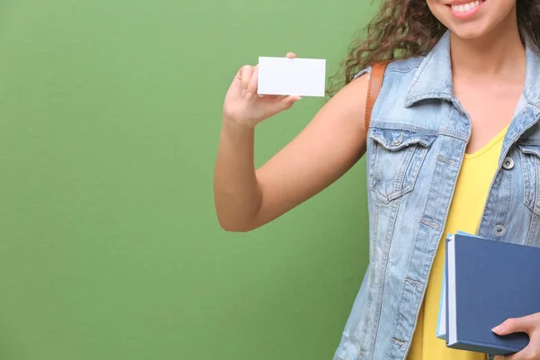 Vrouwelijke student met visitekaartje op kleur achtergrond — Stockfoto