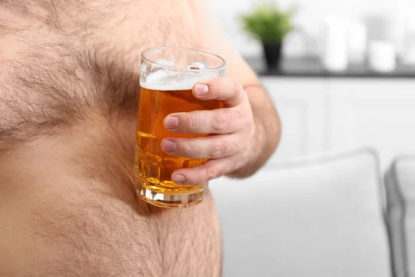 Homem segurando cerveja na barriga grande — Fotografia de Stock