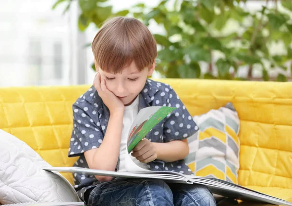 Söt liten pojke läser bok hemma — Stockfoto