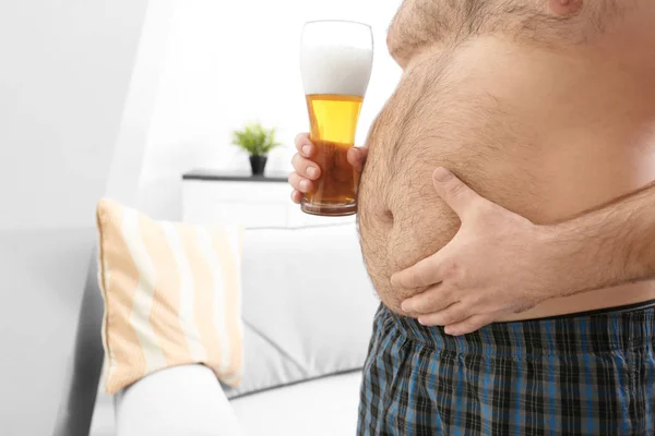 Man with big belly holding beer